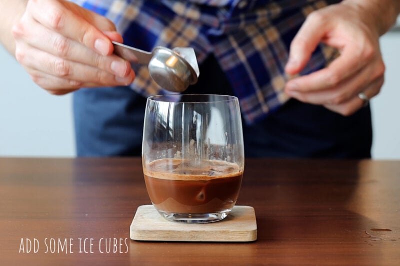 Adding ice cubes into the iced coffee